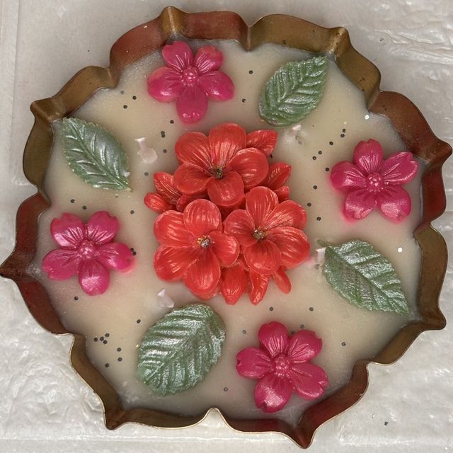 DH-07: Red and pink blooms with leaves on ivory wax, in a scalloped metal tray, close-up of the blooms.