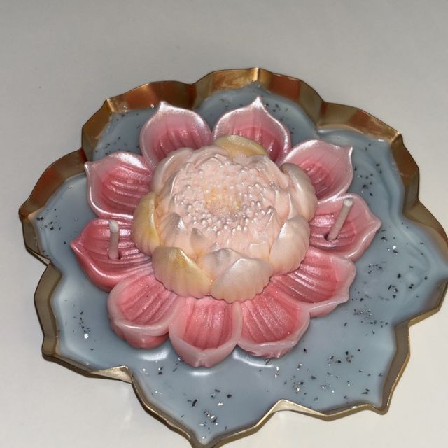 DH-08: A pink lotus on blue wax, in a lotus-shaped metal tray, from the side.