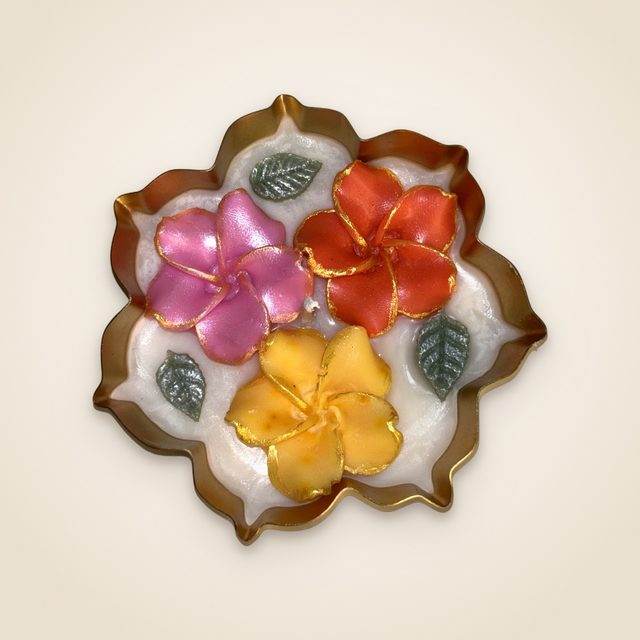 DH-09: Three plumeria blooms in a scalloped gold metal tray.