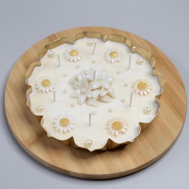 DH-10: White daisies and pearls in a scalloped gold metal tin, from the side.