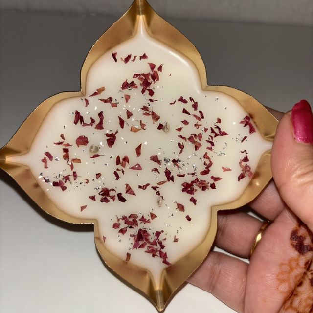 DH-12: Rose petals set in white wax, in a four-point gold metal tray, held in a hand, to show its size.