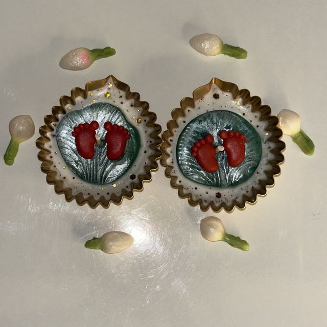DH-16: A pair of diyas with Lakshmi’s footprints, in scalloped gold metal cups, the pair with jasmine buds.